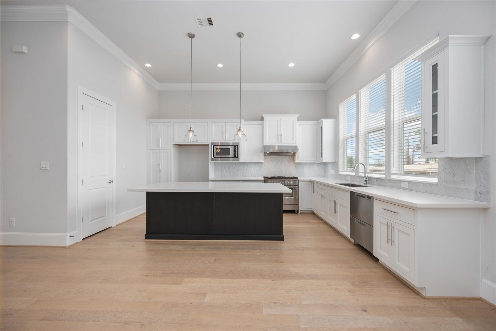 10919 Grove Tree Lane Houston, TX 77043 - Photo 16 of 43 a large kitchen with stainless steel appliances kitchen island granite countertop a large counter top a sink a stove a refrigerator and cabinets