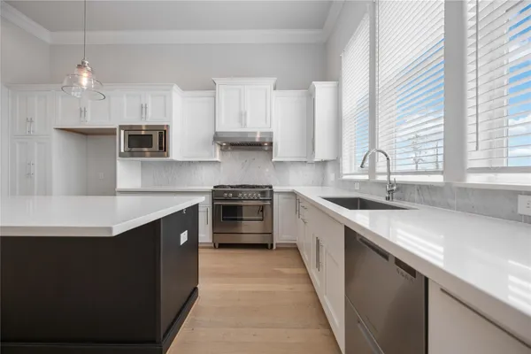a kitchen with stainless steel appliances a sink stove and cabinets