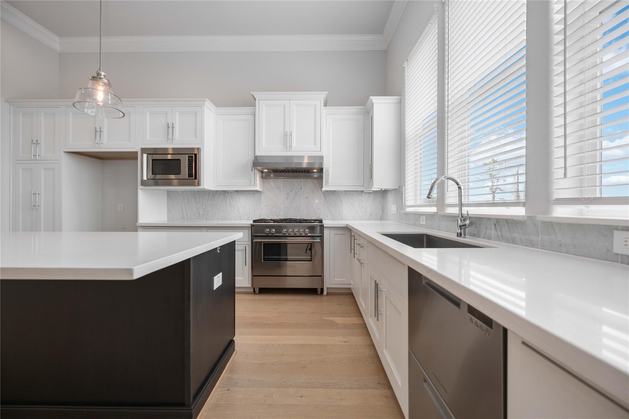 10919 Grove Tree Lane Houston, TX 77043 - Photo 17 of 43 a kitchen with stainless steel appliances a sink stove and cabinets