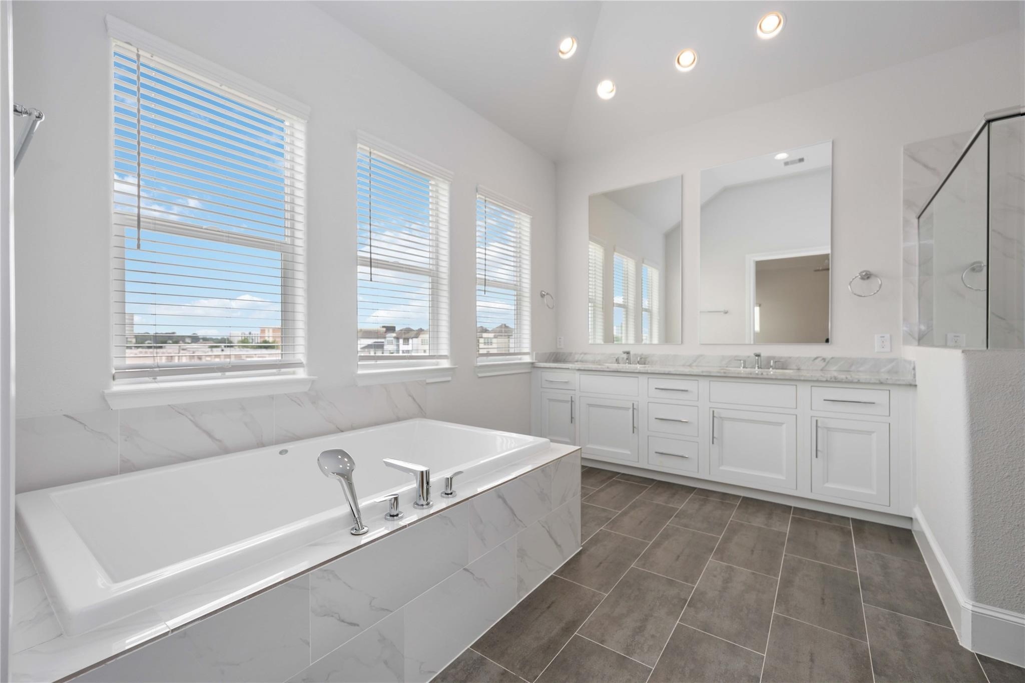 10919 Grove Tree Lane Houston, TX 77043 - Photo 28 of 43 a bathroom with a granite countertop tub sink and mirror