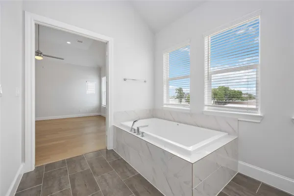 a bathroom with a bathtub a sink and a window
