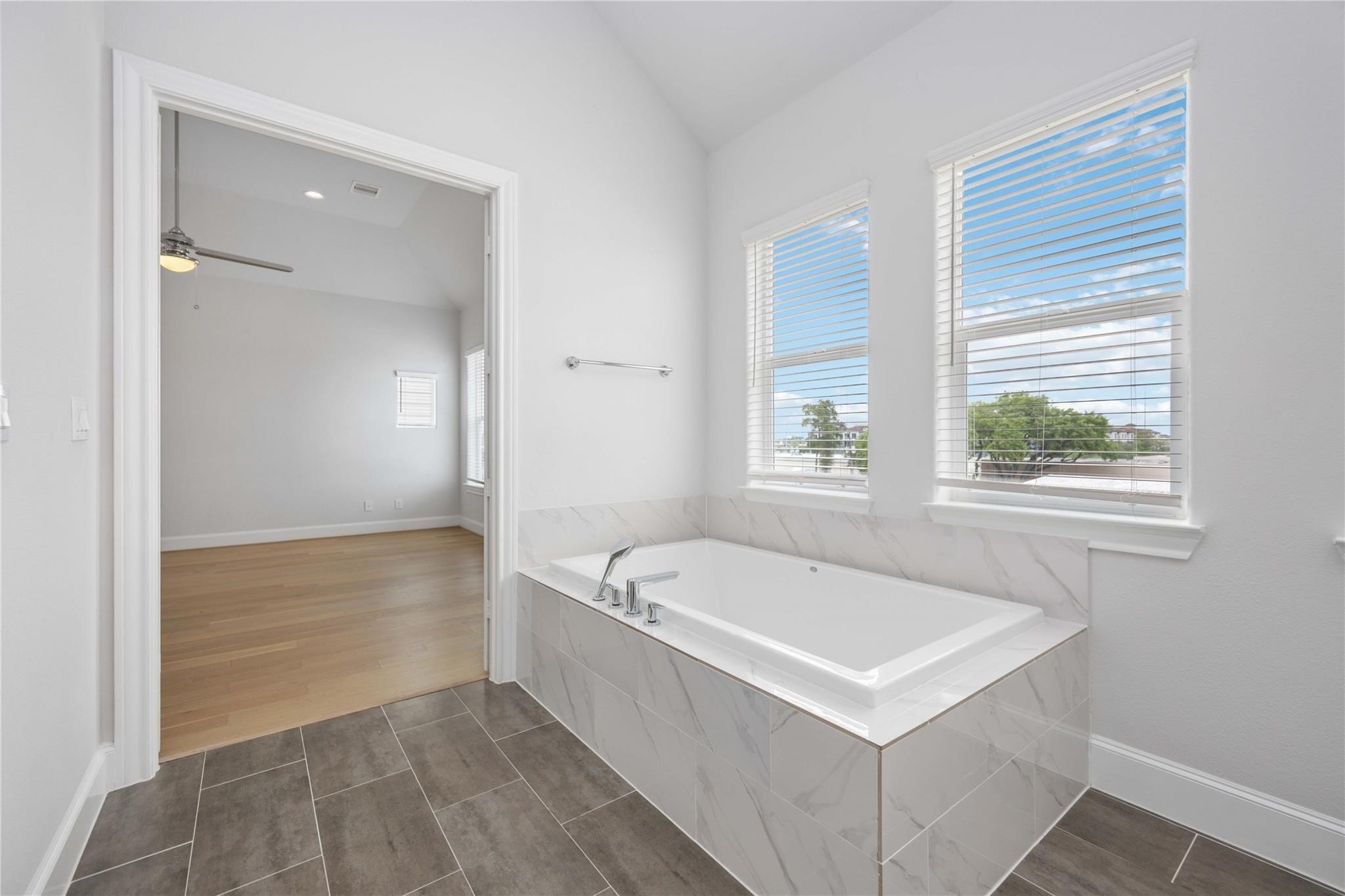 10919 Grove Tree Lane Houston, TX 77043 - Photo 30 of 43 a bathroom with a bathtub a sink and a window