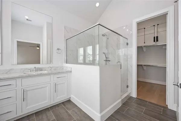 a bathroom with a granite countertop shower sink and mirror
