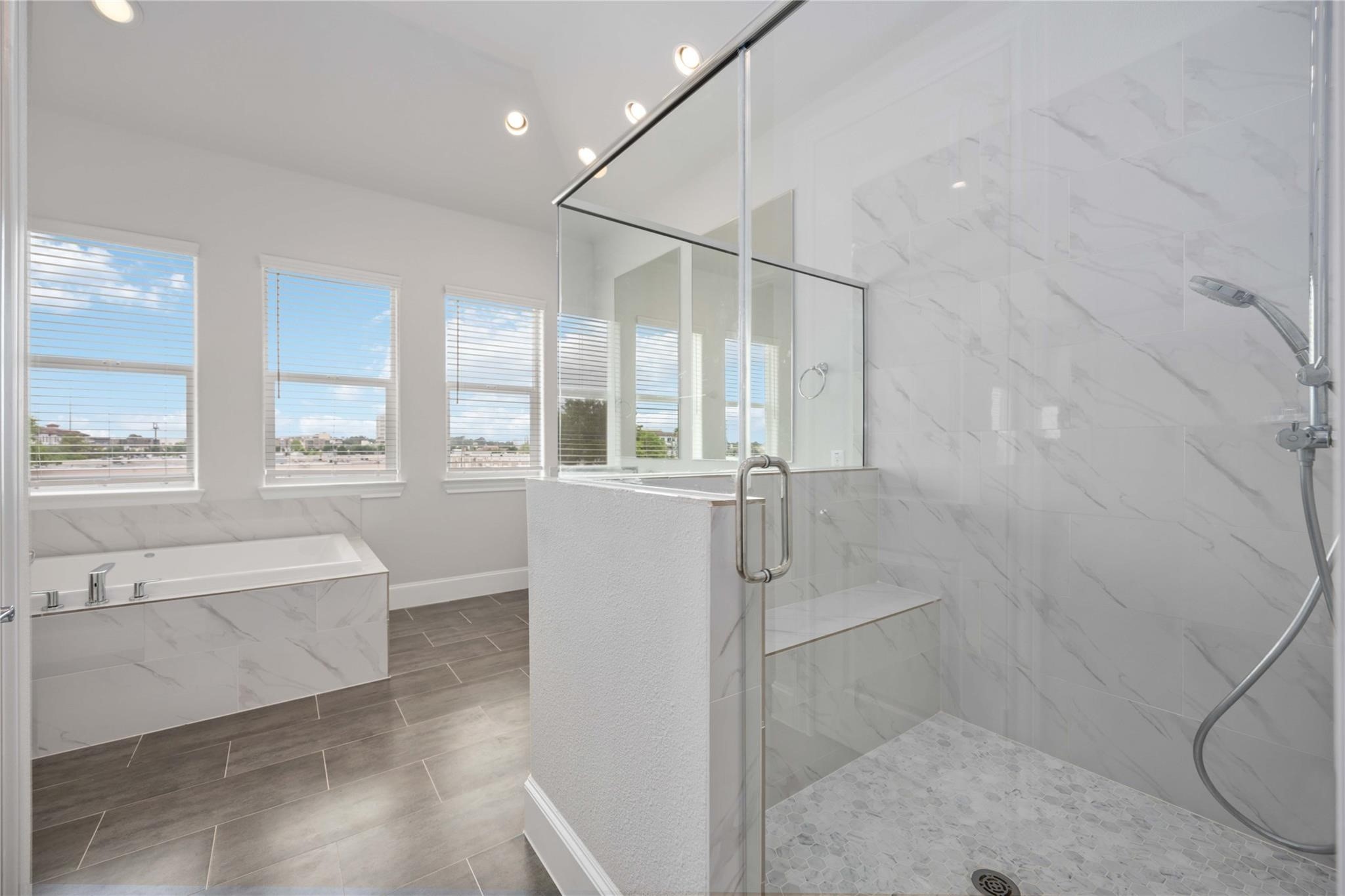 10919 Grove Tree Lane Houston, TX 77043 - Photo 32 of 43 a bathroom with a glass shower door and a bathtub