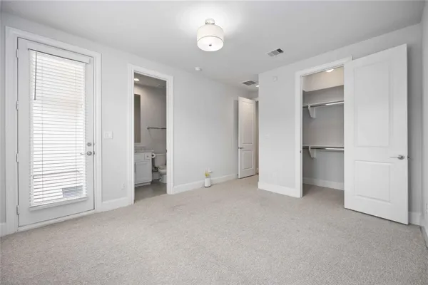 an empty room with a window and a kitchen