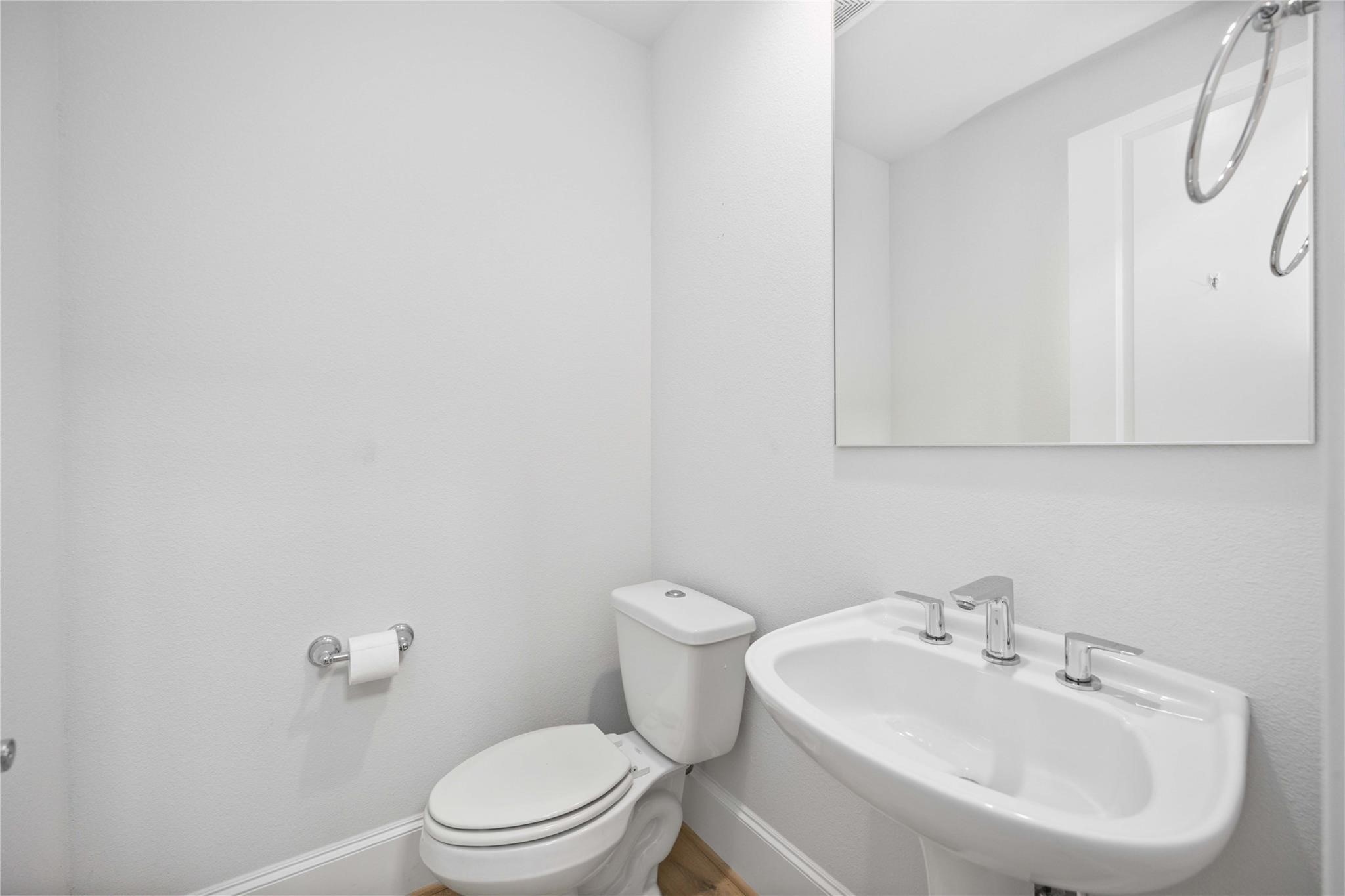 10919 Grove Tree Lane Houston, TX 77043 - Photo 10 of 43 a bathroom with a sink a toilet and a mirror