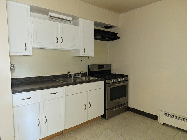 506 Main Street, Unit 3 Marseilles, IL 61341 - Photo 3 of 10 a kitchen with granite countertop white cabinets and black appliances