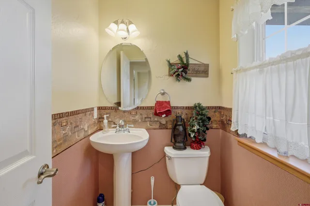 a bathroom with a toilet sink and mirror