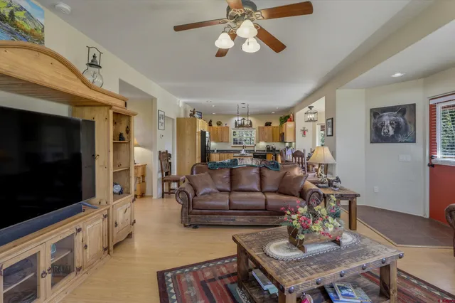 a living room with furniture a flat screen tv and kitchen view