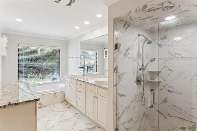 a large white bathroom with a granite countertop sink a toilet a large mirror and shower