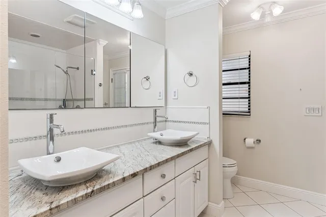 a bathroom with a granite countertop sink a toilet and a mirror
