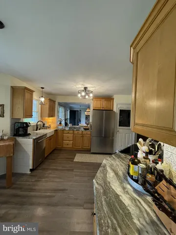 a large living room with stainless steel appliances kitchen island granite countertop a sink and cabinets