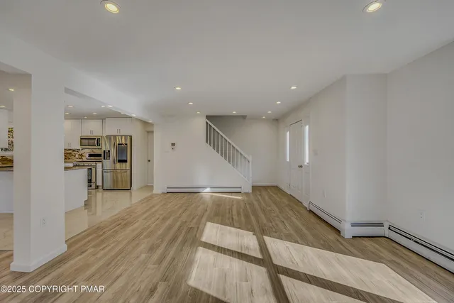 a view of empty room with wooden floor
