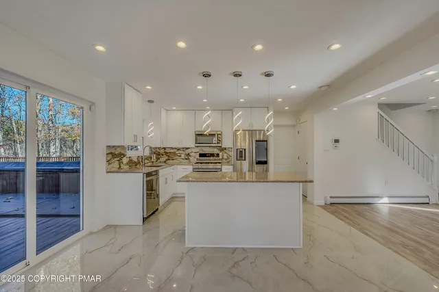 a kitchen with a refrigerator and white cabinets