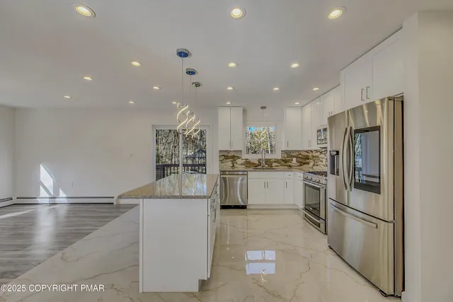 a kitchen with white cabinets and stainless steel appliances