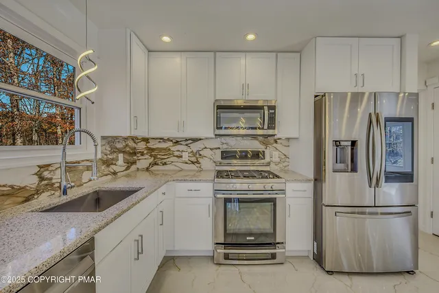 a kitchen with appliances a sink and lots of counter space
