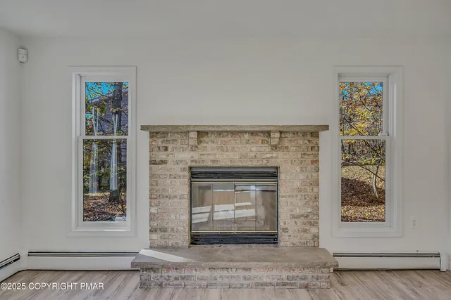 an empty room with fireplace and wooden floor
