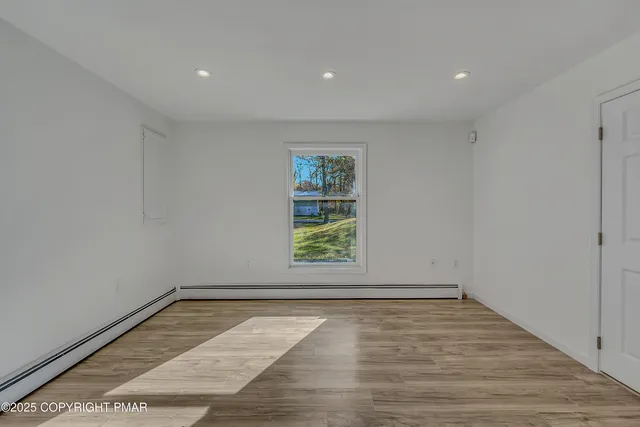 a view of empty room with wooden floor