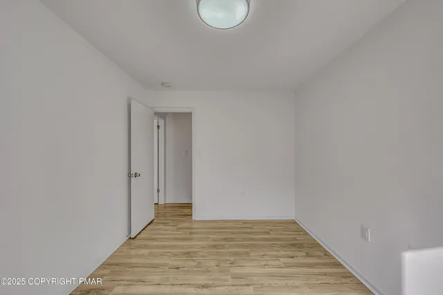 a view of a room with wooden floor and white walls