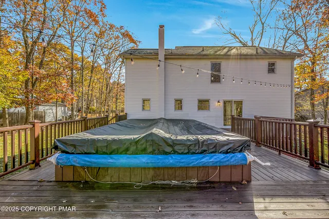 a view of a house with wooden deck and a backyard