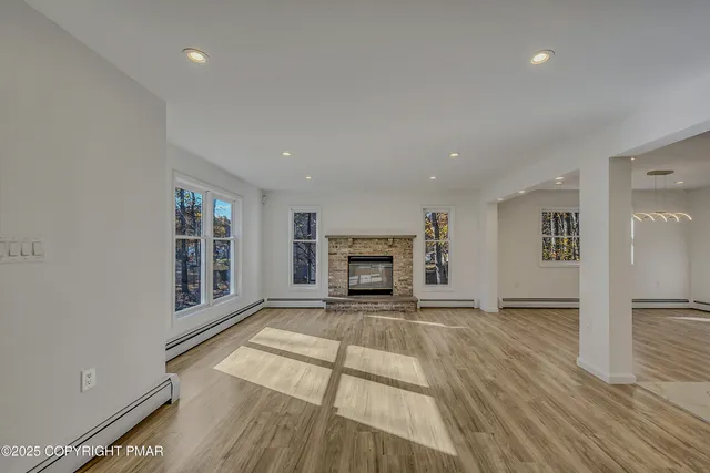 a view of a livingroom with a fireplace and window