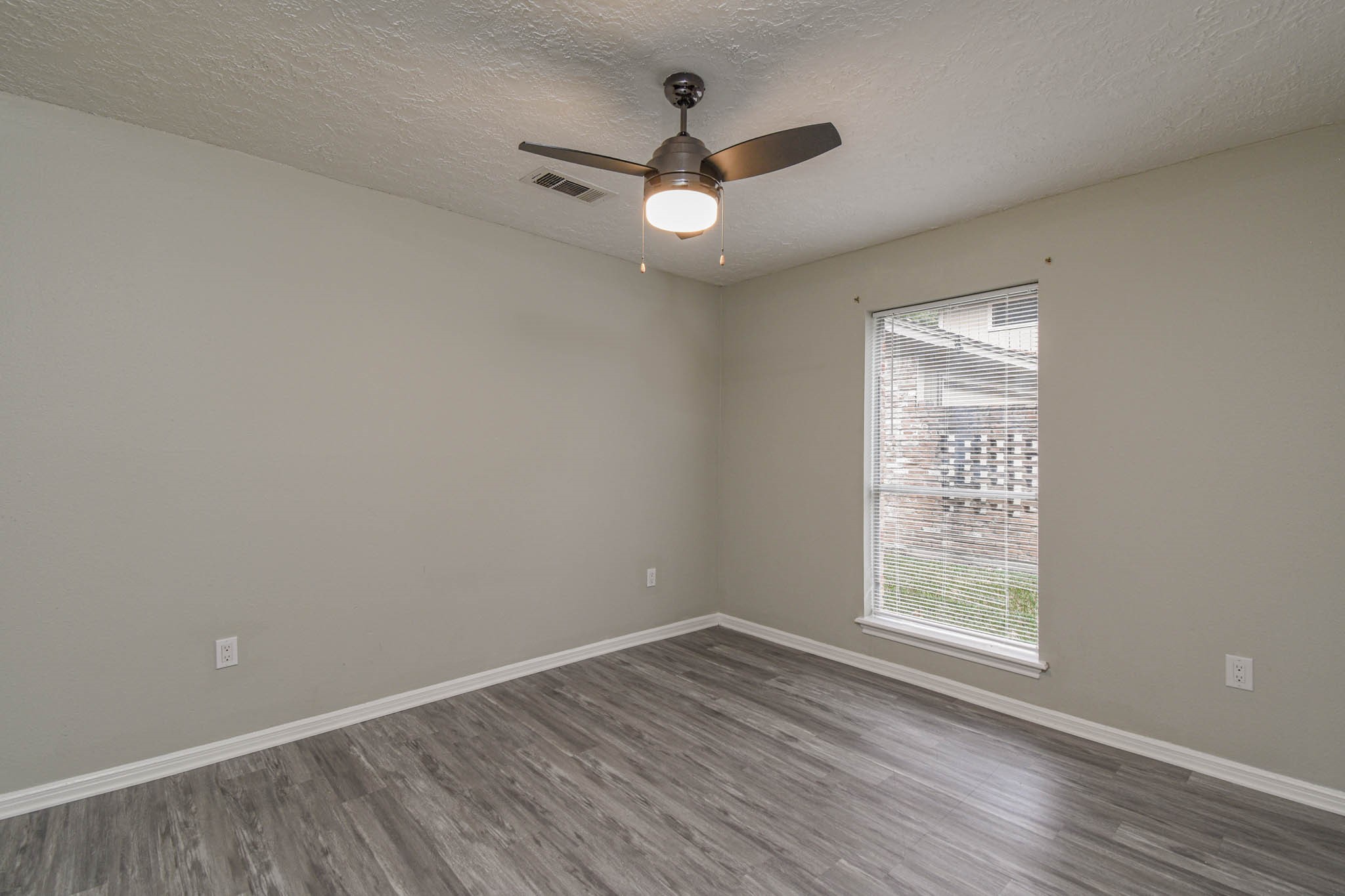 16911 Summit Oaks Lane Spring, TX 77379 - Photo 16 of 24 an empty room with wooden floor chandelier fan and windows