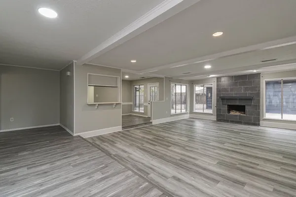 a view of empty room with wooden floor and fireplace