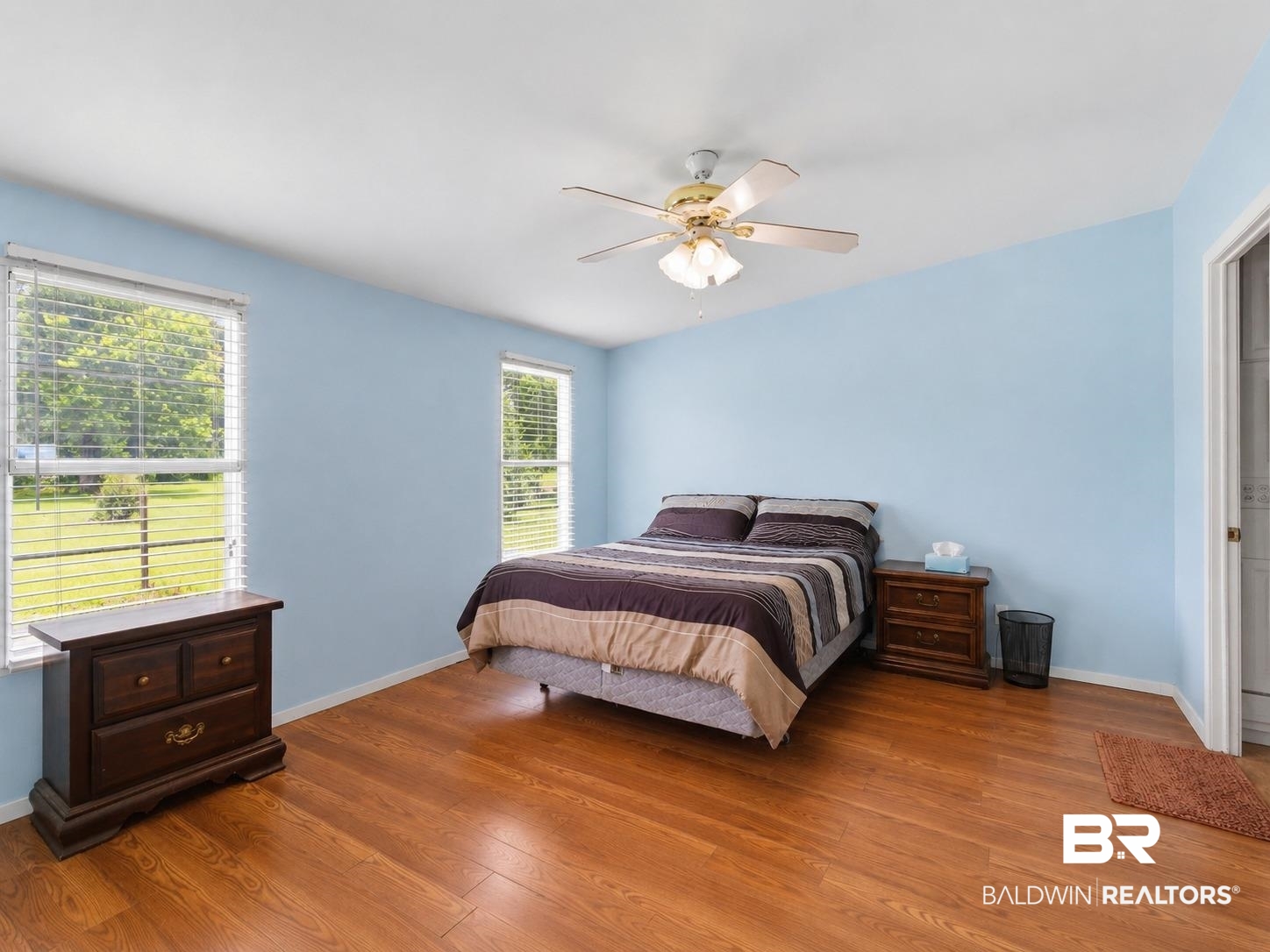 26788 Feely Road Elberta, AL 36530 - Photo 12 of 31 Room featuring wood-finish flooring, two windows with horizontal blinds, a ceiling fan with integrated lighting, and a white interior door