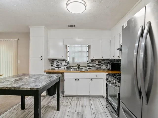 a kitchen with stainless steel appliances granite countertop a stove refrigerator sink and cabinets