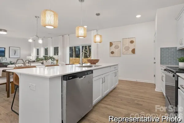 a kitchen with stainless steel appliances a sink stove and cabinets
