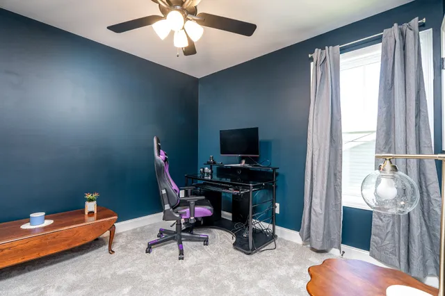 a view of a workspace with furniture and a window