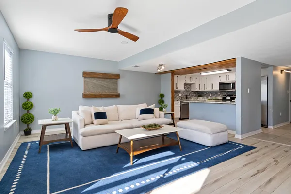 a living room with furniture and a view of kitchen