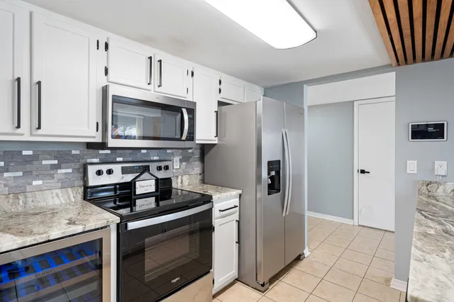 a kitchen with stainless steel appliances granite countertop a stove a refrigerator and a microwave