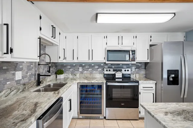 a kitchen with stainless steel appliances granite countertop a stove microwave and sink