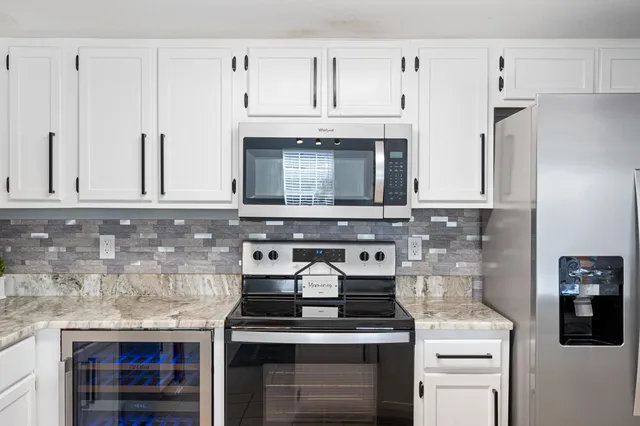 a kitchen with stainless steel appliances granite countertop a stove and a cabinets