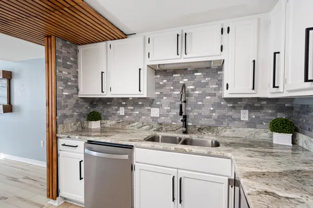a kitchen with stainless steel appliances white cabinets and a refrigerator