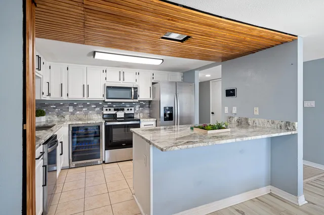 a kitchen with stainless steel appliances granite countertop a sink a stove and cabinets
