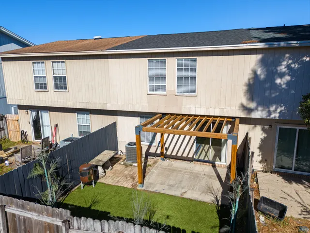 a view of a patio with table and chairs with wooden floor and fence