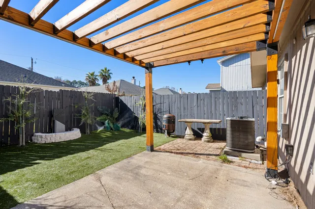 a view of a chair and table in backyard of the house