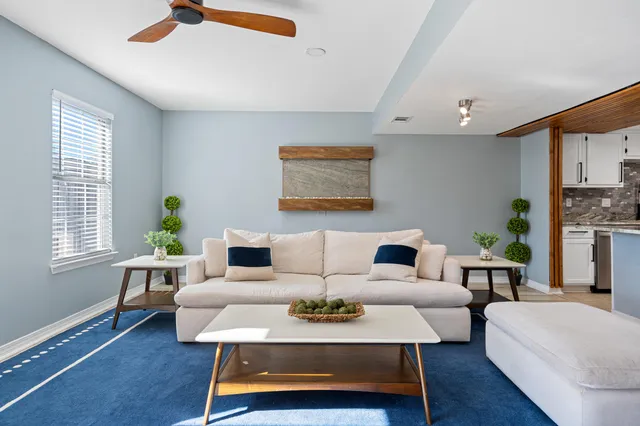 a living room with furniture a wooden floor and a chandelier