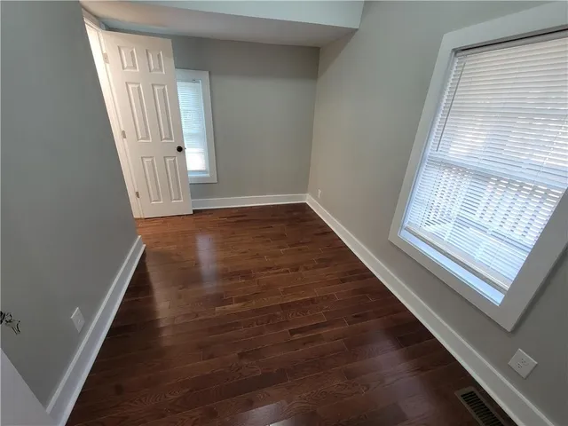 a view of a hallway with wooden floor and staircase
