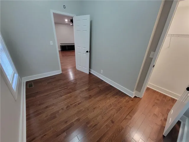 a view of a hallway with wooden floor and staircase