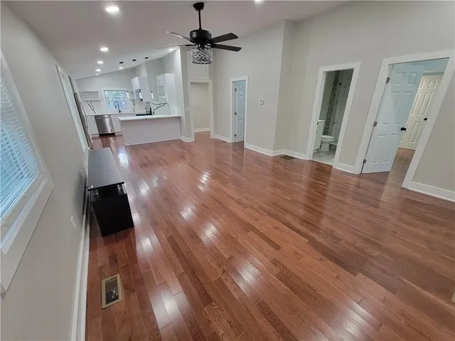 a view of a hallway with wooden floor and chandelier