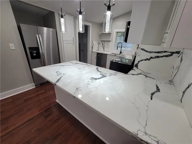 a kitchen with stainless steel appliances a refrigerator and wooden floor