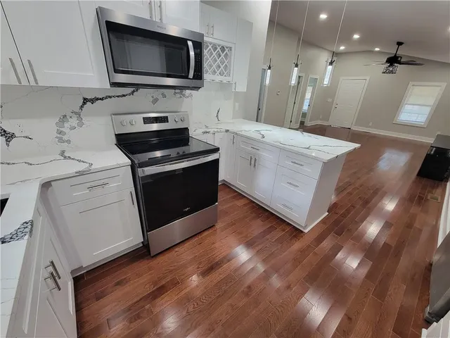 a view of living room with stainless steel appliances wooden floor and view living room