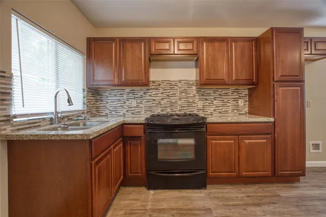 a kitchen with stainless steel appliances granite countertop a sink stove and cabinets