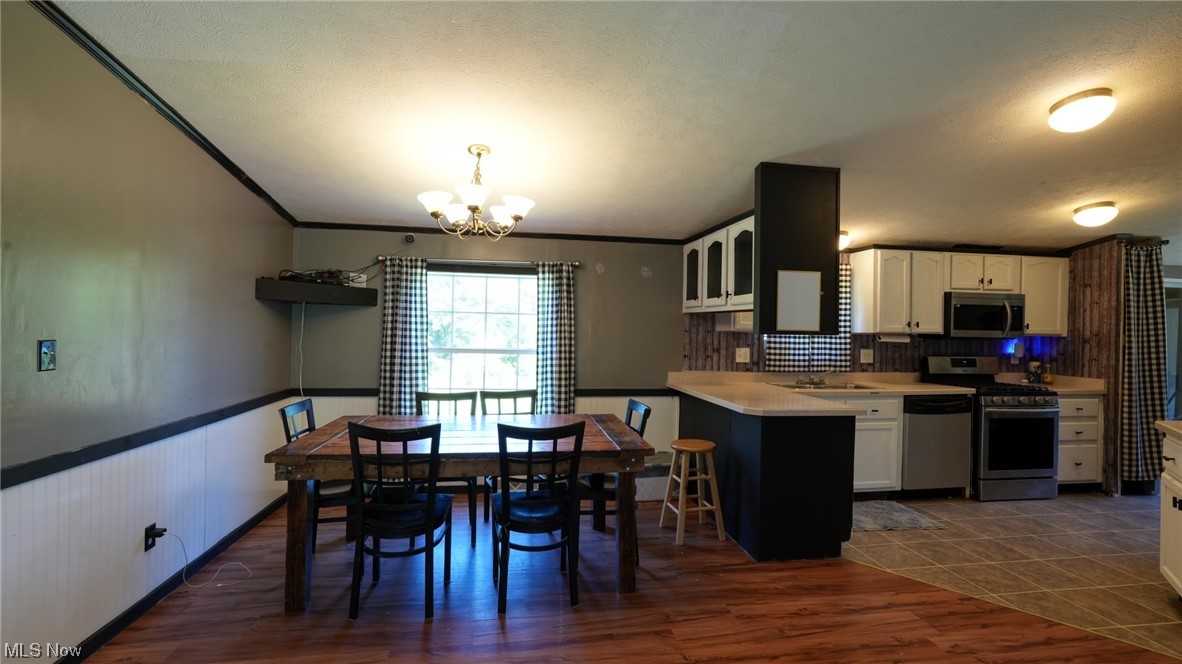 70871 Angus Road Cambridge, OH 43725 - Photo 21 of 29 Kitchen with dark tile floors, stainless steel appliances, backsplash, and white cabinetry