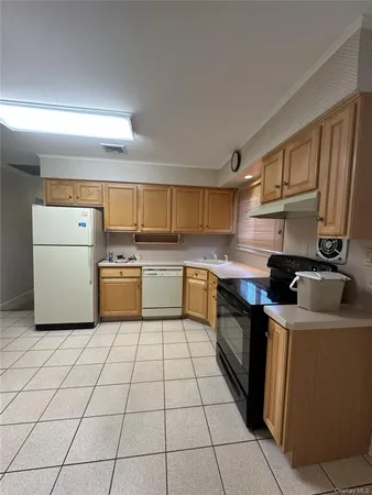 a kitchen with a sink a stove top oven and white cabinets