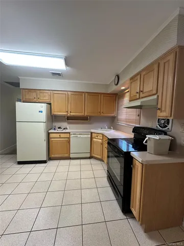 a kitchen with a sink a stove top oven and white cabinets