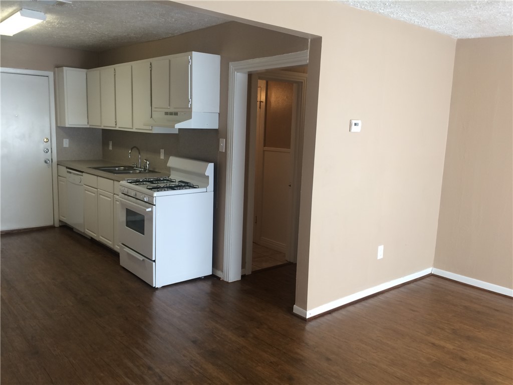 106 Hardy Street Bryan, TX 77801 - Photo 13 of 27 a kitchen with wooden floors and white cabinets